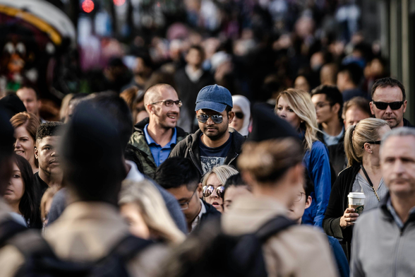 a photo of a crowded sidewalk where some people are in focus while others are not