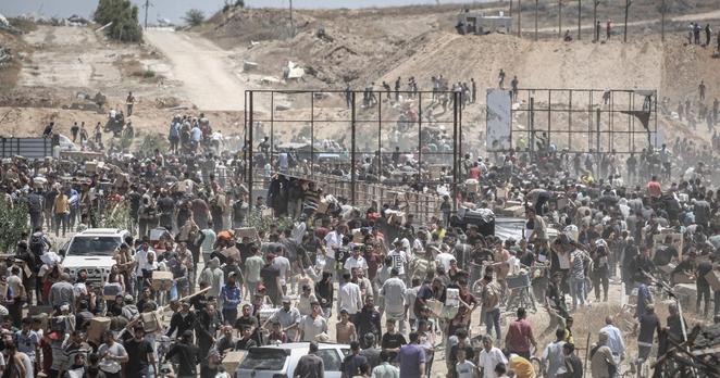 Palästinenser*nnen an einer von den USA unterstützten Verteilungsstelle für humanitäre Hilfe der Gaza Humanitarian Foundation im „Netzarim-Korridor“ im Zentrum des Gazastreifens, 29. Mai 2025.