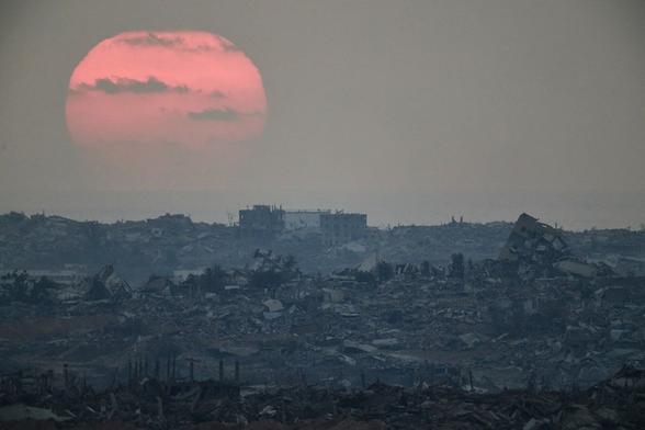 The sun sets behind buildings that were destroyed during the Israeli ground and air operations stand in the northern Gaza Strip, Occupied Palestine, Friday, Aug. 8, 2025 (AP)