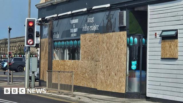 A photo showing the front of an Indian restaurant in Lowestoft. Large wooden boards can be seen covering majority of the restaurant's windows. A photo showing the front of an Indian restaurant in Lowestoft. Large wooden boards can be seen covering majority of the restaurant's windows.