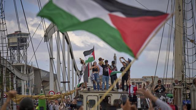 Activists wave on a boat taking part in a civilian flotilla bound for Gaza, aiming to break the Israeli blockade and deliver humanitarian aid, in Barcelona, Spain, Sunday, Aug. 31, 2025. (AP Photo/Emilio Morenatti)