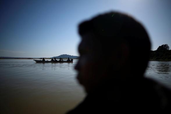 Die Silhouette eines Mannes und ein Kanu auf einem Fluss