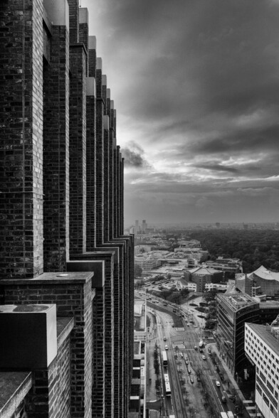 Blick vom Panoramapunkt Potsdamer Platz herunter auf die Stadt, am linken Bildrand ist die Backsteinfassade des Kollhoff-Towers zu erkennen. Schwarz-Weiß-Foto