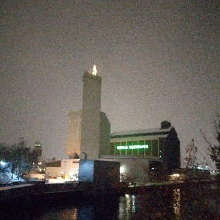 Eine Industrielandschaft.
Rechts ein dunkles Gebäude (Lagerhaus, kaum Fenster) mit  hellgrünen Leuchtbuchstaben "BEHALA WESTHAFEN".
Links kleinere Gebäude. 
In der Mitte ein graues, hohes, schlankes Gebäude ohne Fenster. Oben darauf ein länglicher, heller Fleck, von dem der Fotograph versichert, daß es sich um einen Weihnachtsbaum handelt.
Vor den Gebäuden ist eine Wasserfläche, hinter ihnen grauer Himmel.