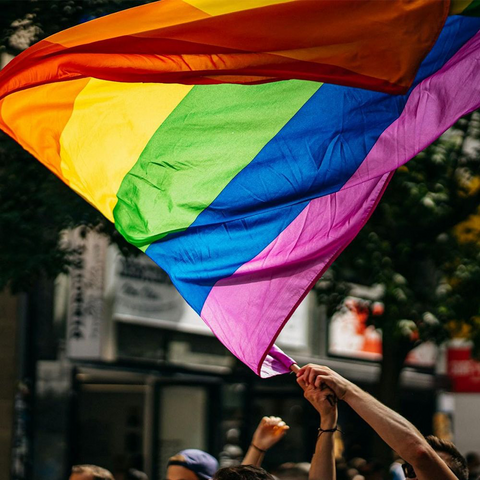 Das Foto zeigt eine geschwenkte LGBTIQ*-Fahne. Nachweis: Raphael Renter | @raphi_rawr / Unsplash
