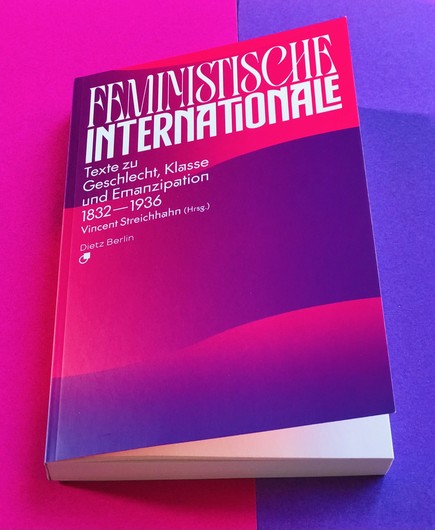 Auf Farbpapieren in Pink und Lila, den Farben des Covers, liegt unser Buch: »Feministische Internationale. Texte zu Geschlecht, Klasse und Emanzipation 1832—1936«, herausgegeben von Vincent Streichhahn