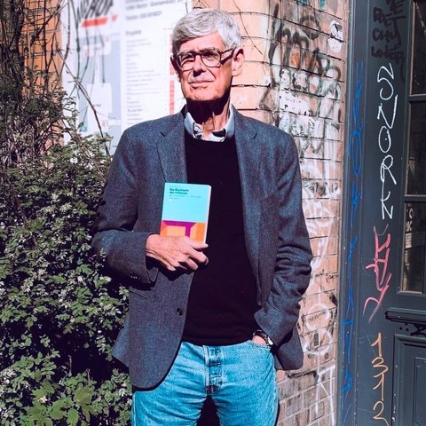 Autor Paul Mattick hält sein Buch in Händen: »Die Rückkehr der Inflation. Geld und Kapital im 21. Jahrhundert«, erschienen bei uns.
