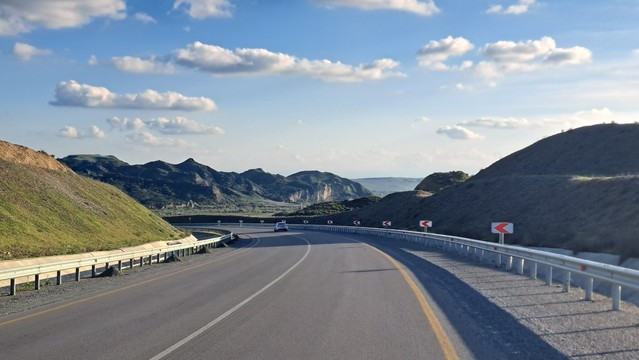 Straßenkurve mit wunderschönen Bergen im Hintergrund 
