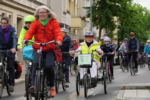 Ältere Menschen fahren Fahrrad. Sie nutzen dabei unterschiedliche Räder: zum Beispiel auch Dreiräder.