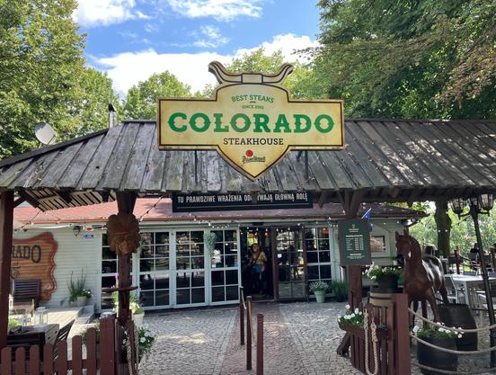Das Foto zeigt das Schild eines polnischen Steakhauses mit dem Namen "Colorado", das damit die Bedingungen der "Steakhouse-Verschwörung" erfüllt, die auf http://www.grillmaster2000.de/files/weltverschwoerung1.html im Detail erklärt wird.