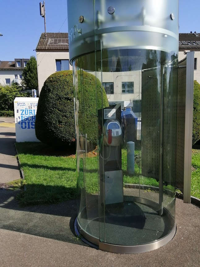 An extremely posh call box, an ample glass cylinder with a metal column holding the phone in the middle. 