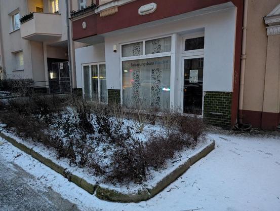 Die wei&szlig;e Front des Betreuungsb&uuml;ros. Vor dem B&uuml;ro ist ein kleines Feld aktuell mit leider etwas k&auml;rglichen Pflanzen. Alles ist leicht mit Schnee bedeckt.
