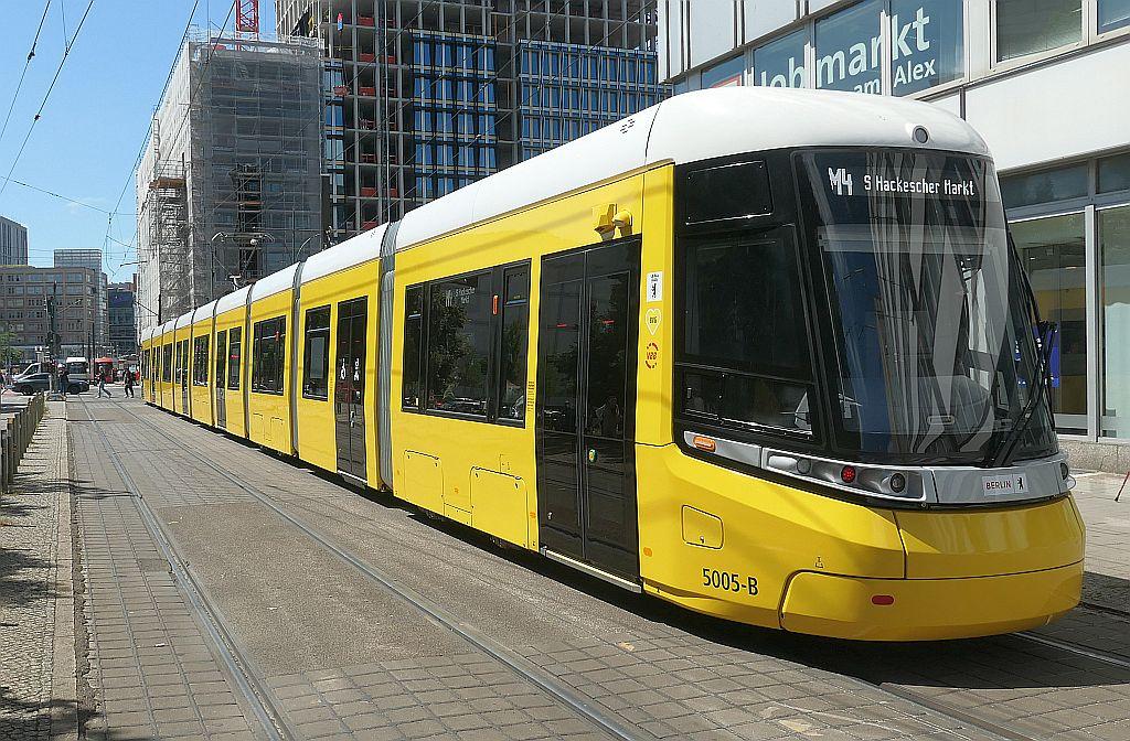 Straßenbahn in einer Fußgängerzone, im Hintergrund eine Hochhaus-Baustelle