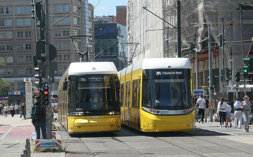 Zwei Straßenbahnen nebeneinander in einer Fußgängerzone